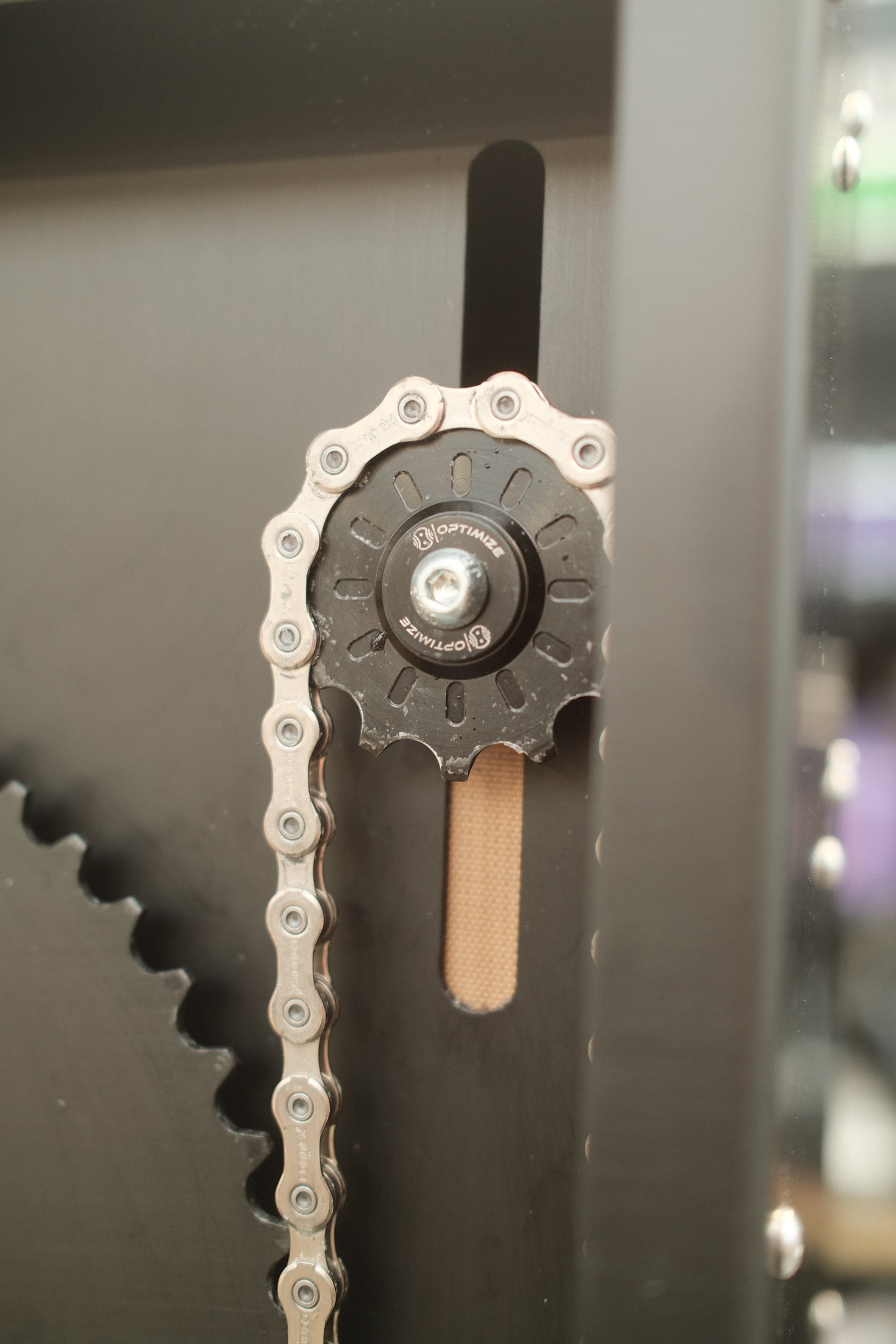 Nahaufnahme einer Fahrrad-Kettenschaltung mit Kette auf einem schwarzen Rahmen, die mechanische und schaltungstechnische Details hervorhebt - perfekt für alle, die ihre Fahrradkette mit dem Optimize Kettenbrecher elektrisch der Optimize GmbH optimieren wollen.