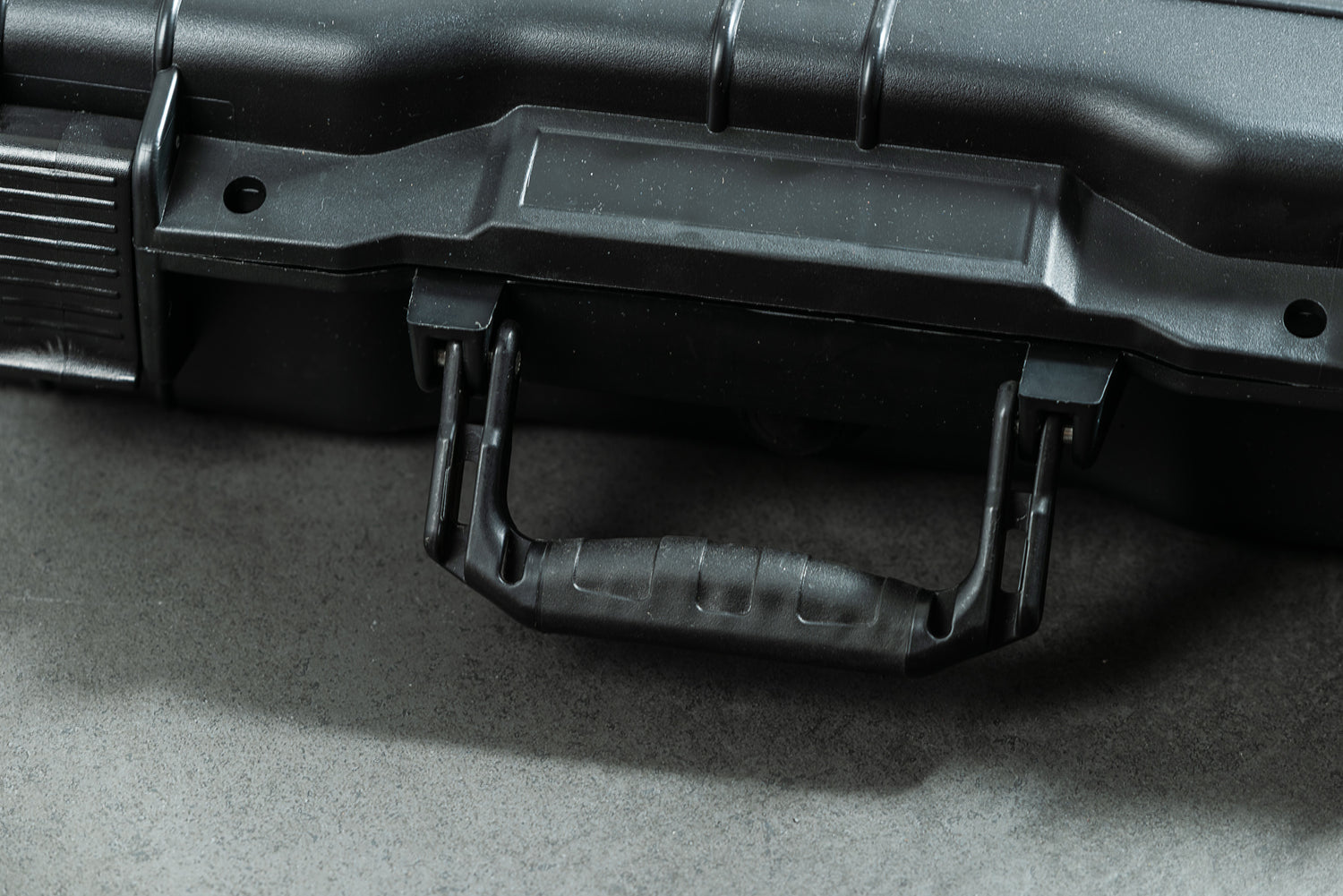 Eine Nahaufnahme des schwarzen Optimize GmbH Optimize Werkzeugkoffers mit einem stabilen Griff, der auf einer grauen Oberfläche ruht.