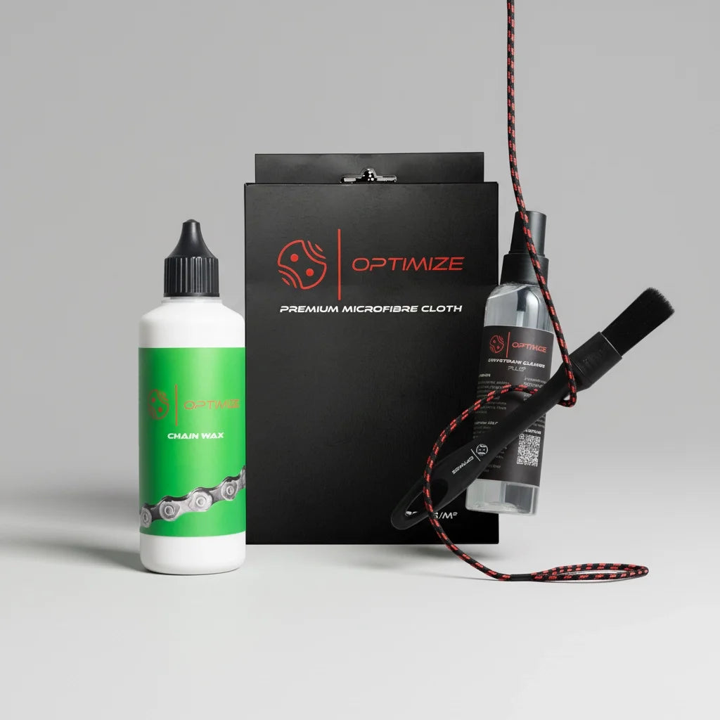 Das Wachs Starterset - Basic von Fast Bundle, bestehend aus Kettenwachs, Reinigungsspray, Bürste, Mikrofasertuchbox und rot-schwarzer Kordel, ist übersichtlich auf einer schlichten grauen Fläche mit hellgrauem Hintergrund angeordnet.