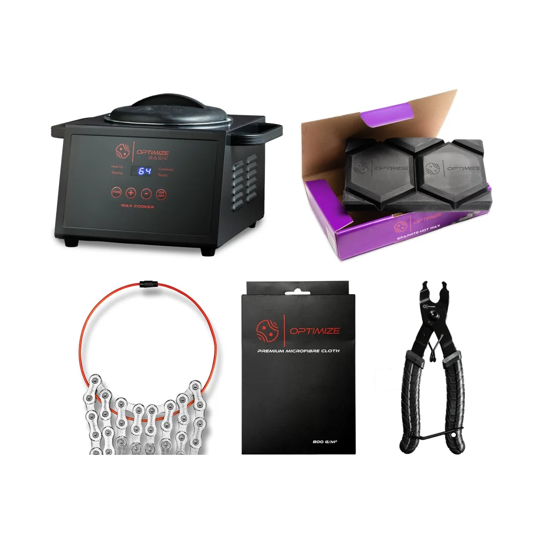 Das Fast Bundle Heißwachs Starter-Set enthält einen schwarzen Wachskocher, zwei sechseckige Wachsstangen in einer lila Box, eine silberne Fahrradkette mit rotem Kabel, ein verpacktes schwarzes Mikrofasertuch und eine Kettenzange mit schwarzem Griff auf weißem Hintergrund.