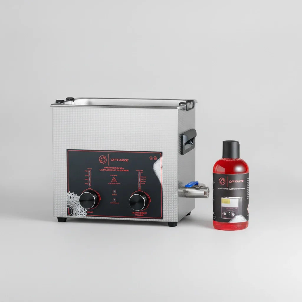 Ein professionelles Ultraschallbad-Set von Fast Bundle, bestehend aus einem Edelstahlgehäuse mit einem schwarz-roten Bedienfeld und zwei Drehreglern sowie einer Flasche roter Ultraschall-Reinigungsflüssigkeit – alles vor einem schlichten grauen Hintergrund – ideal für alle, die Fahrradteile reinigen möchten.