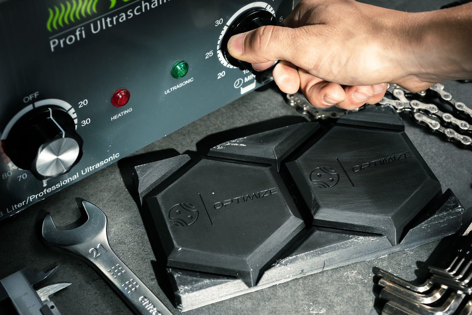 Person entfettet eine Fahrradkette in einem Ultraschallbad