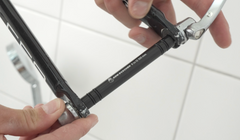 Hände, die einen schwarzen 12 x 100 mm Schnellspanner-Adapter in eine Fahrradgabel einsetzen.