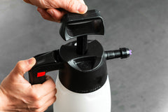 Hände, die den Pumpmechanismus eines IK FOAM Pro 2 – Pumpsprüher für die Fahrradwartung – bedienen.
