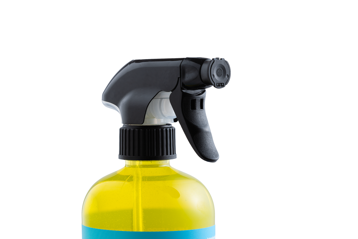 Eine durchsichtige Sprühflasche aus Kunststoff, gefüllt mit gelbem Intensivreiniger – gebrauchsfertig, mit einer schwarzen Sprühdüse.
