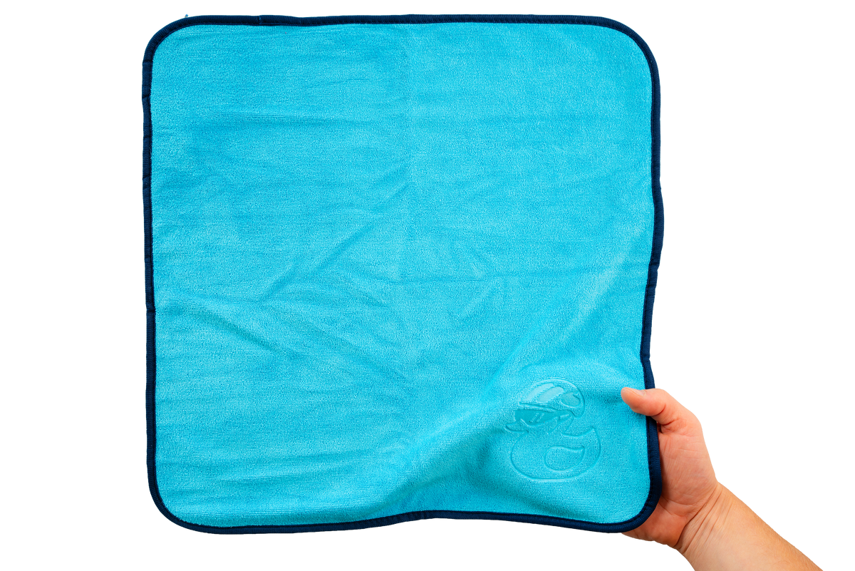 Eine Hand hält ein leuchtend blaues Mikrofasertuch – Reinigungstücher 400 g/m² (4 Stück) – mit einem dunkelblauen Rand und einem kleinen geprägten Enten-Symbol, ideal für die Haushaltsreinigung.