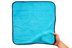 Eine Hand hält ein leuchtend blaues Mikrofasertuch – Reinigungstücher 400 g/m² (4 Stück) – mit einem dunkelblauen Rand und einem kleinen geprägten Enten-Symbol, ideal für die Haushaltsreinigung.