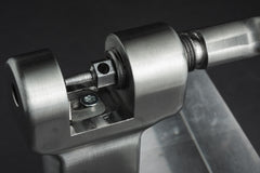 Nahaufnahme des „Optimize Kettennieter“ der Optimize GmbH, eines metallmechanischen Bauteils mit zylindrischen und sechseckigen Teilen, die präzise mittels CNC-Fräse bearbeitet wurden, sowie mit Montageelementen aus Edelstahl, montiert auf einem Metallsockel.
